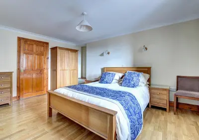 a bedroom with a large bed with blue pillows at Hen Ysgubor in Lampeter