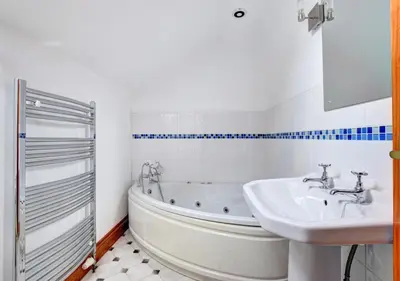 a bathroom with a white tub and a sink at Hen Ysgubor in Lampeter
