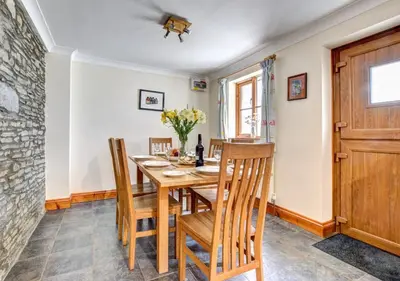 a dining room with a wooden table and chairs at Hen Ysgubor in Lampeter