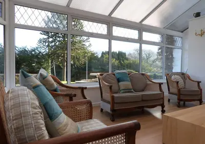 a living room with furniture and large windows at Ysgubor Illtyd in Dolgellau
