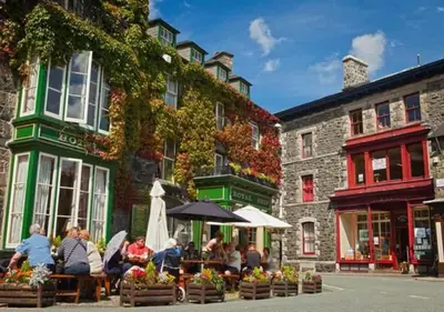 a group of people sitting at tables outside a building at Ysgubor Illtyd in Dolgellau