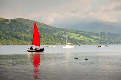 a small boat with a red sail in a lake at 2 Bed in Bala oc-82212 in Bala