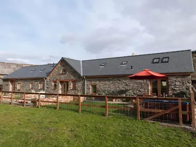 a stone building with a red umbrella in front of it at 2 Bed in Bala oc-82212 in Bala