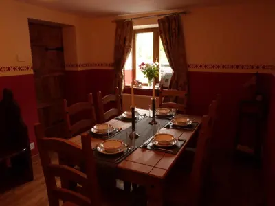 a dining room with a wooden table and chairs at Troed yr Aran in Aber Cowarch