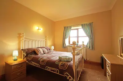 a bedroom with a bed and a window at Y Ddinas in Llanilar