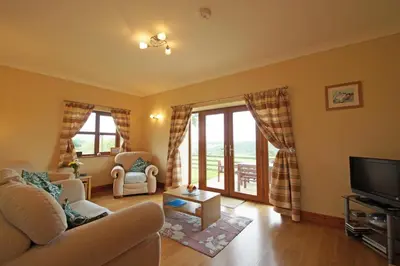 a living room with a couch and a tv at Y Ddinas in Llanilar