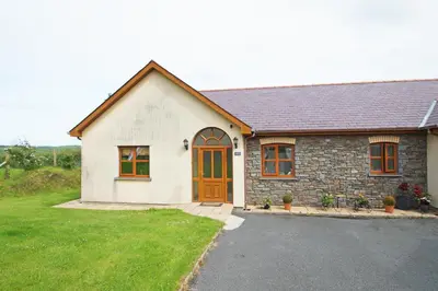a small white house with a door and a yard at Y Ddinas in Llanilar