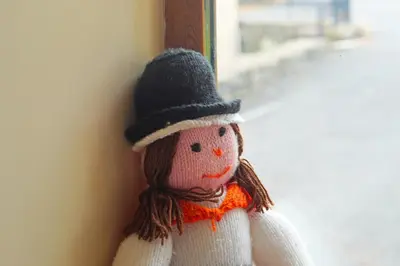a doll wearing a hat is leaning against a wall at Y Ddinas in Llanilar