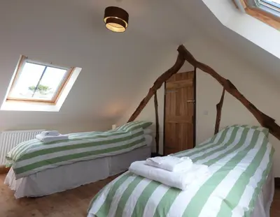 two green and white beds in a room with a window at Ysgubor y Waun in Tywyn