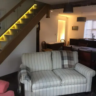 a living room with a couch and a staircase at Top House in Welshpool
