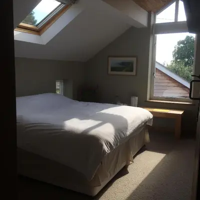 a bedroom with a bed and a large window at Top House in Welshpool