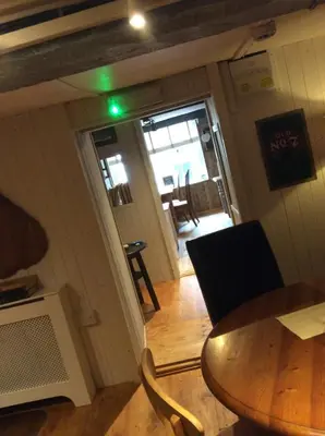 a room with a table and chairs and a green light at The Bear Inn in Llandovery