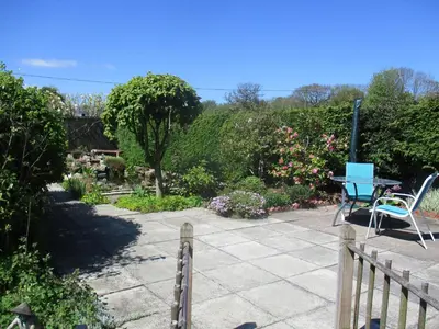 a patio with a table and chairs in a garden at The Garden Lodge in Llynclys