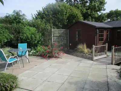 a patio with a table and chairs and a fence at The Garden Lodge in Llynclys
