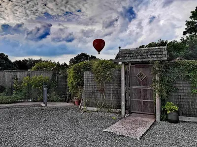 a hot air balloon flying over a garden with a fence at The Garden Lodge in Llynclys