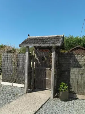 a wooden fence with a gate and a potted plant at The Garden Lodge in Llynclys