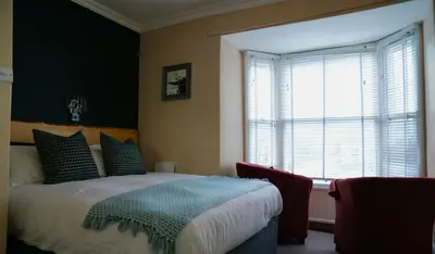 a bedroom with a bed and a large window at Arosfa Harbourside Aberaeron in Aberaeron