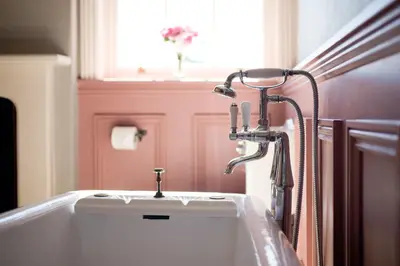 a bathroom with a bath tub with a faucet at Burton Court in Dilwyn