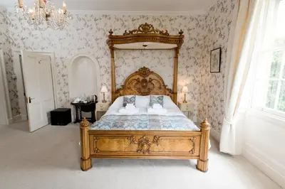 a bedroom with a large wooden bed in a room at Burton Court in Dilwyn