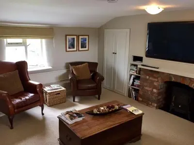 a living room with a fireplace and a flat screen tv at The Old Three Pigeons in Nesscliffe