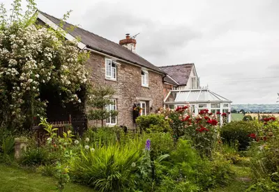 an old house with a garden in front of it at The Smithy in Hay-on-Wye