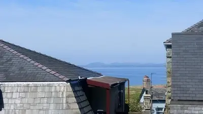 a view of the water from the roofs of two houses at Byrdir House in Harlech
