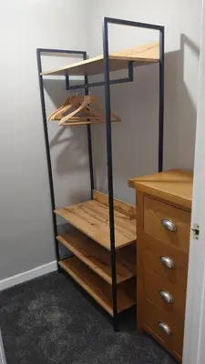a closet with wooden shelves and a wooden desk at Byrdir House in Harlech