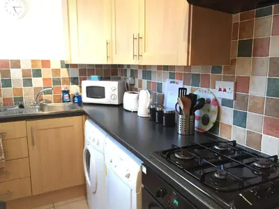a kitchen counter with a stove and a microwave at No 6 Boleyn House in Brecon