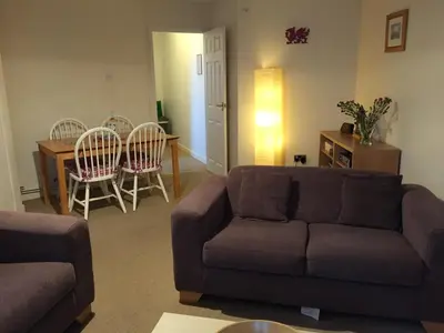 a living room with a couch and a table and chairs at No 6 Boleyn House in Brecon