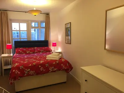 a bedroom with a bed with a red comforter and a mirror at No 6 Boleyn House in Brecon
