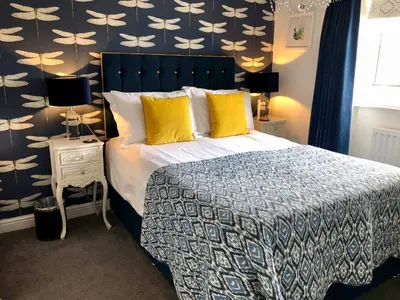 a bedroom with a large bed with yellow pillows at The Town House BnB in Brecon