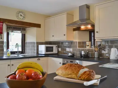 a kitchen with a bowl of fruit and a bowl of bread at Llaethdy-Milkhouse in Talgarth
