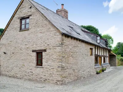 an old stone building with a roof at Mill Cottage in Peterchurch