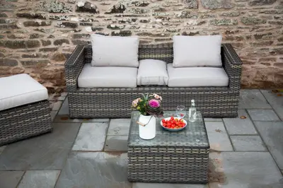 a patio with a couch and a table with a bowl of fruit at Drovers Rest Farm Stay in Hay-on-Wye