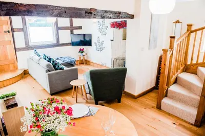 a living room with a couch and a table at Thursdays Corner Tudor Cottage in Church Stretton