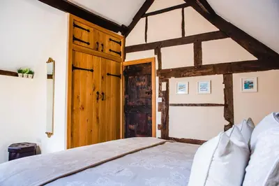 a bedroom with a bed and a wooden door at Thursdays Corner Tudor Cottage in Church Stretton