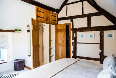 a bedroom with a bed and an open door at Thursdays Corner Tudor Cottage in Church Stretton