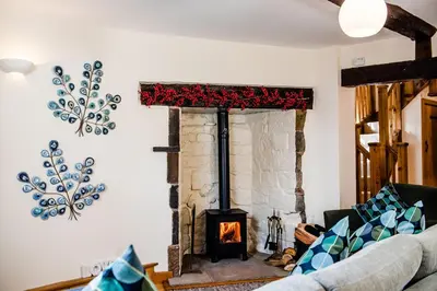 a living room with a fireplace and a couch at Thursdays Corner Tudor Cottage in Church Stretton
