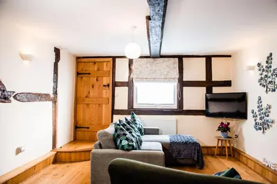 a living room with a couch and a tv at Thursdays Corner Tudor Cottage in Church Stretton