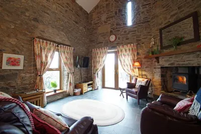 a living room with a couch and a fireplace at Foel Fach in Talerddig