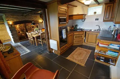 a kitchen with a table and a dining room at Foel Fach in Talerddig