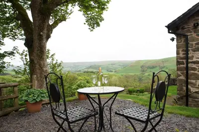 a table and chairs with a view of the hills at Foel Fach in Talerddig