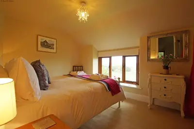 a bedroom with a large bed and a window at Foel Fach in Talerddig