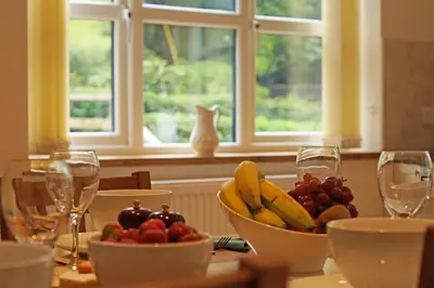 a table with a bowl of fruit and wine glasses at Hen Gapel in Aberhosan
