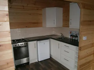 a kitchen with white cabinets and a stove at Long Mountain Centre Log Cabins in Meadowtown