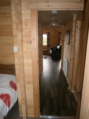 a view of a room with a bed and a living room at Long Mountain Centre Log Cabins in Meadowtown