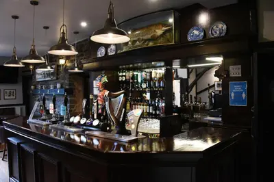 a bar with a lot of bottles of alcohol at The Llanelwedd Arms Hotel in Builth Wells