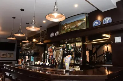 a bar with a mirror above the bar at The Llanelwedd Arms Hotel in Builth Wells