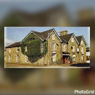 a picture of a large house with ivy on it at The Llanelwedd Arms Hotel in Builth Wells