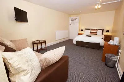 a hotel room with a bed and a couch at The Black Swan Inn in Leominster